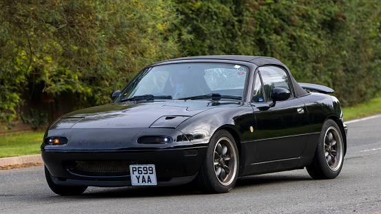 Whittlebury,Northants,UK -Aug 27th 2023: 1997 black Mazda MX 5 car travelling on an English country road