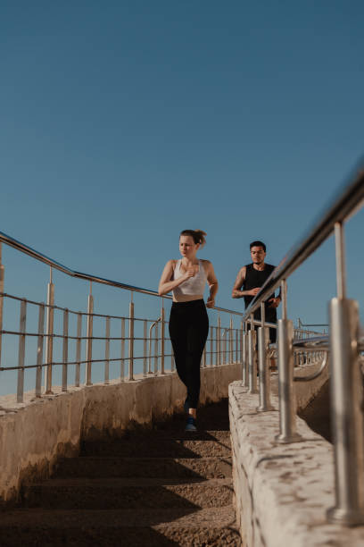 istock Two confident young people in sportswear running downstairs while training outdoors together 1648233875