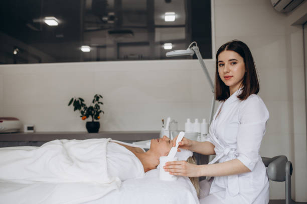 istock Woman beautician makes a face massage to patient in bathrobe 1648250074