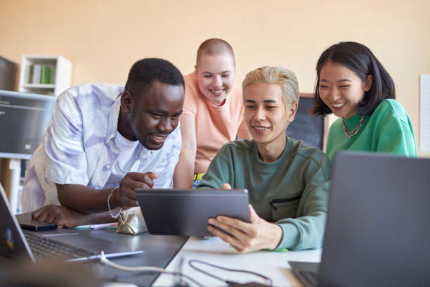 istock Group of happy intercultural students discussing data on screen of tablet 1648252236
