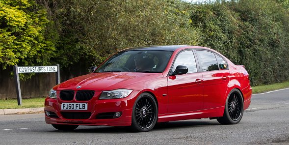 Whittlebury,Northants,UK -Aug 27th 2023:  2010 red BMW Alpina car travelling on an English country road