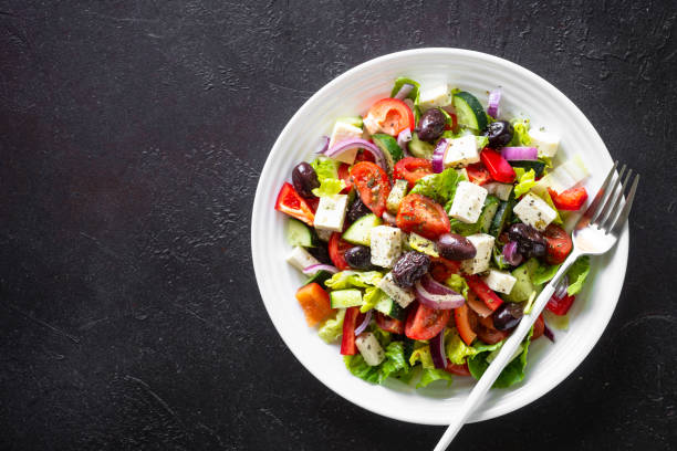 istock Greek salad with olives at black. 1648268445