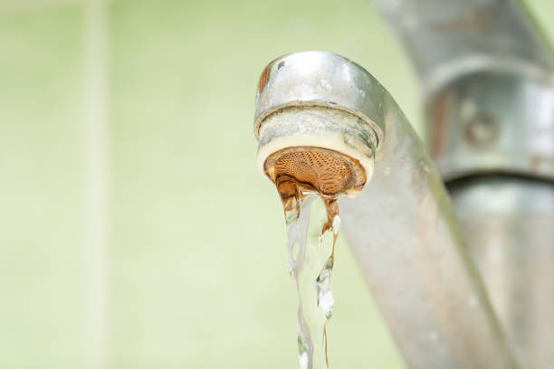 istock Old dirty faucet with flowing water close up 1648270659
