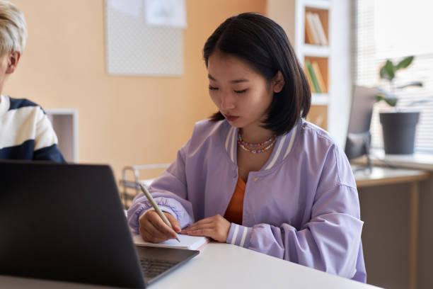 istock Young student of highschool looking through her notes in copybook 1648271806