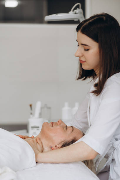 istock Cosmetologist doing face treatment and applying face mask 1648277687