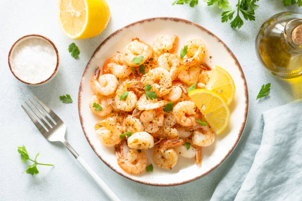 istock Shrimps with spices in craft plate at white stone table. 1648288398
