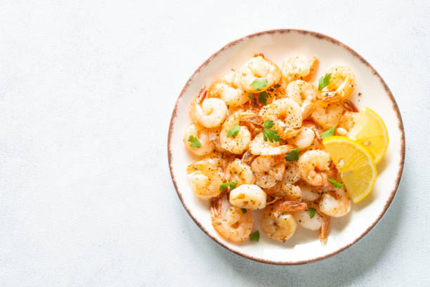 istock Shrimps with spices in craft plate at white stone table. 1648288406
