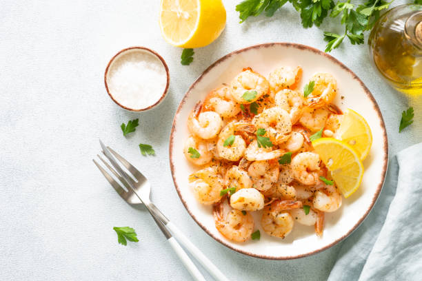 istock Shrimps with spices in craft plate at white stone table. 1648288629