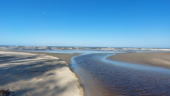 Brazil coast in winter. Sand dunes , river , beach and blue sky.
