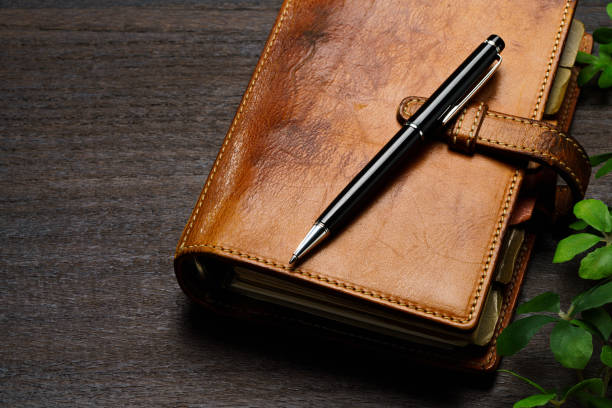 istock Ring bound planner and pen on wooden table 1648312459