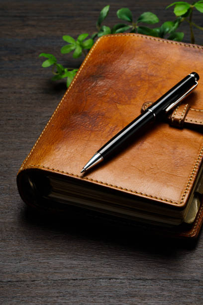 istock Ring bound planner and pen on wooden table 1648312474