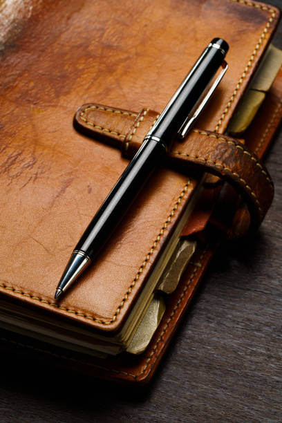 istock Ring bound planner and pen on wooden table 1648313003