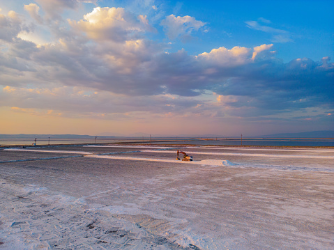 Lake salt harvest with digger at sunset.