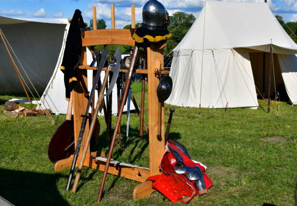 istock A close up on a wooden stand with various medieval weapons displayed on it, including some wooden swords, polearms, shields, axes, scimitars, and other ones seen on a sunny summer day in Poland 1648340614