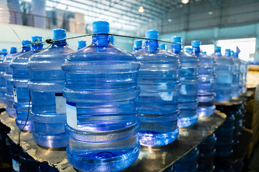 Plastic bottle or tank for drinking water in production line of factory. Process of filling water into plastic bottles to bring out to consumers. gallon drink water manufacturing.