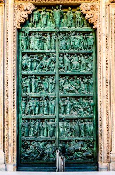 Milan, Italy -  August 16, 2019: Ornate Milan Cathedral door illustrated with people
