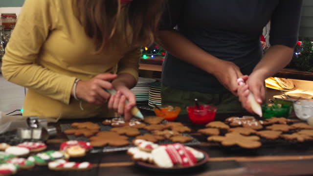 Teenage Girls Decorating Christmas Cookies with Icing