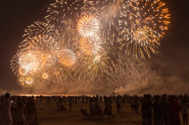 Fireworks on the beach. New year celebration on the beach crowded with people. Santos city, Brazil. Fireworks on the beach. New year celebration on the beach crowded with people. Santos city, Brazil. new year urban scene horizontal people stock pictures, royalty-free photos & images