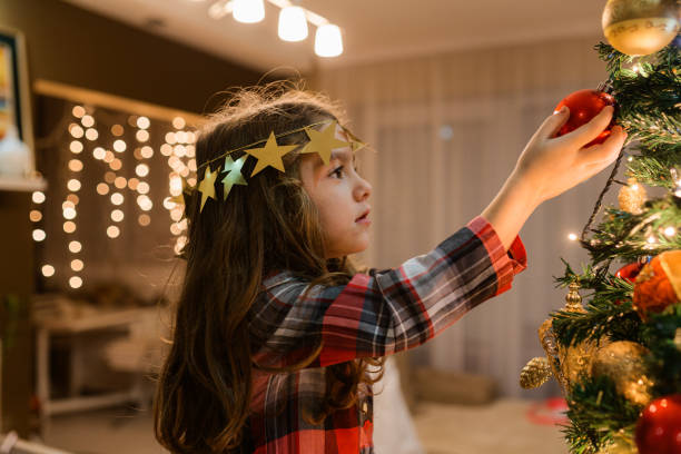 istock Cheerful girl decorating the Christmas tree 1648429527