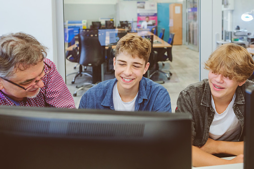 Teenage Students Wearing Uniform Studying In IT Class