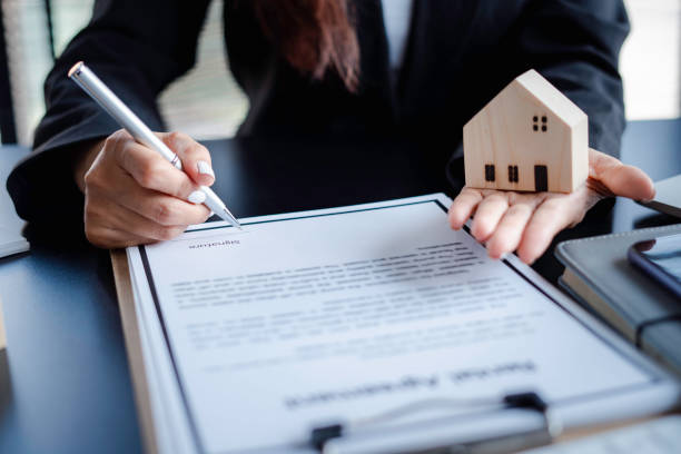 istock Real estate agents are proposing a model home and signing for a housing project approval, a model house proposal idea, and a purchase contract signing. 1648451053