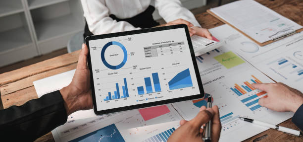 istock Business People Meeting using laptop computer,calculator,notebook,stock market chart paper for analysis Plans to improve quality next month. Conference Discussion Corporate Concept. 1648451506