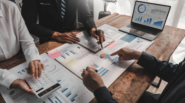 istock Business People Meeting using laptop computer,calculator,notebook,stock market chart paper for analysis Plans to improve quality next month. Conference Discussion Corporate Concept. 1648451727