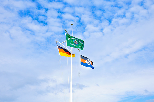 Spiekeroog, Germany, August, 23, 2023 - Flags at the beach of Spiekeroog Island, East Friesian Island,