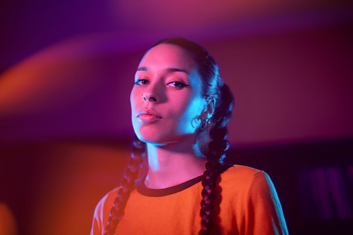 Young woman portrait under neon colored lights