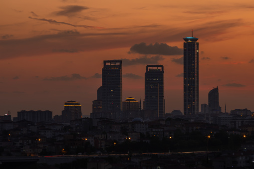 Istanbul cityscape with skyscrapers at orange sunset.
