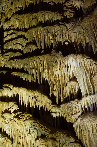 Karst cave, stunning view of stalactites and stalagnites illuminated by bright light, a beautiful natural attraction in a tourist place in Georgia, which is called Prometheus Cave.