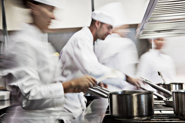 köche kochen in restaurant kitchen - kochkleidung stock-fotos und bilder