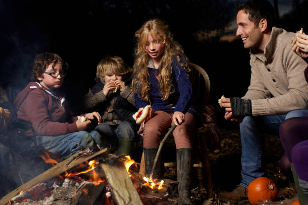 istock Family eating around campfire at night 164851116
