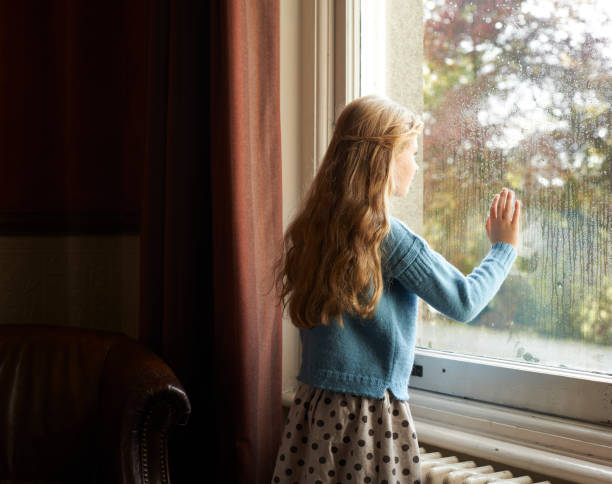 istock Girl looking out window 164851129