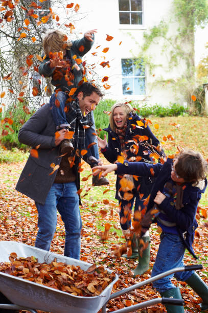 family playing in autumn leaves - family happiness outdoors autumn стоковые фото и изображения