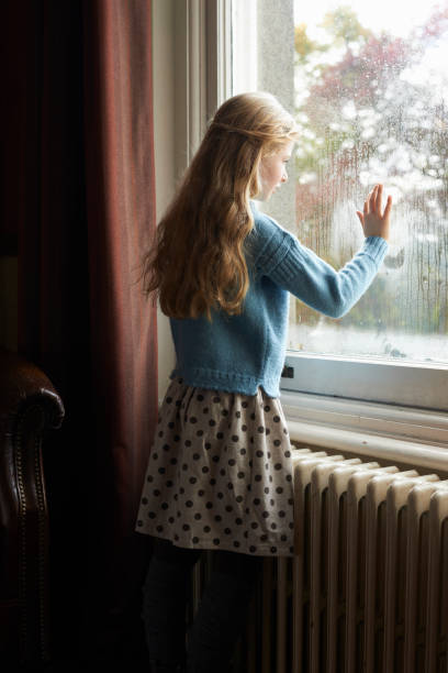 istock Girl looking out window 164851374
