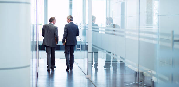 istock Businessmen talking in office hallway 164852188