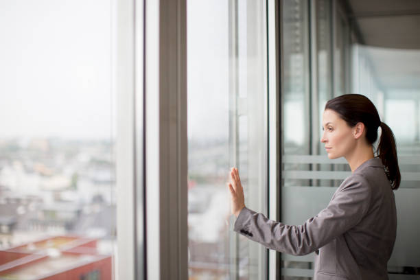 istock Businesswoman standing at office window 164852191