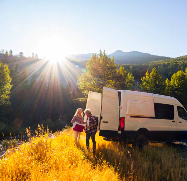 un couple d’âge mûr quitte un camping-car avec une glacière de pique- - motor home park camping luxury photos et images de collection