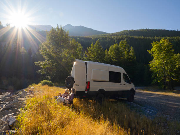 istock Mature couple relax with drinks beside campervan 1648523843