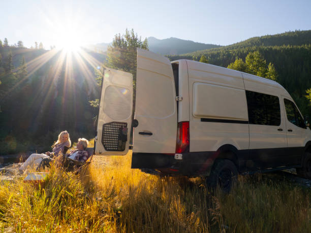 Mature couple relax beside camper van