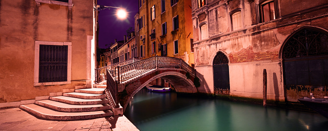 Venetian street at night. Bridge over the canal. Venice, Italy