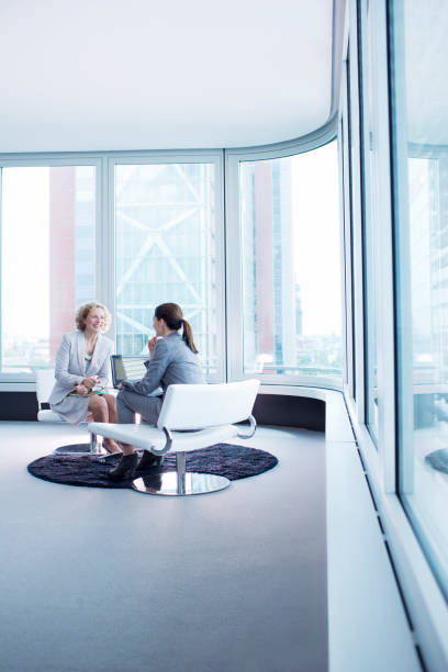 istock Businesswomen talking in office lobby 164852504