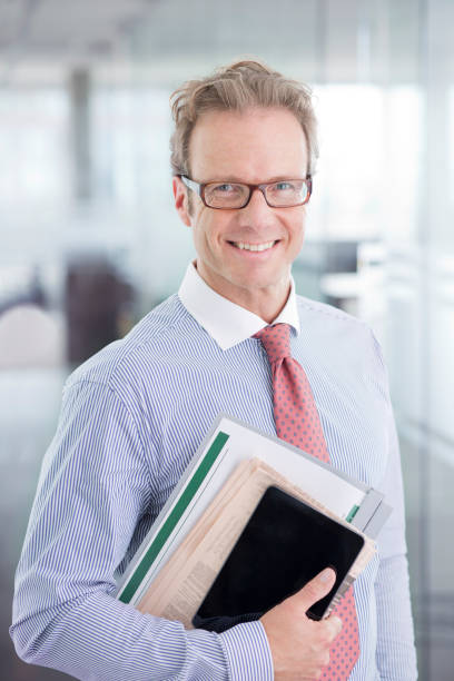 istock Businessman smiling in office hallway 164852518