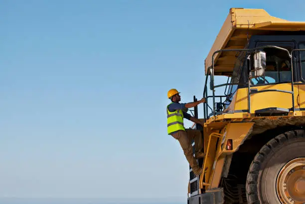 Photo of Worker climbing machinery on site