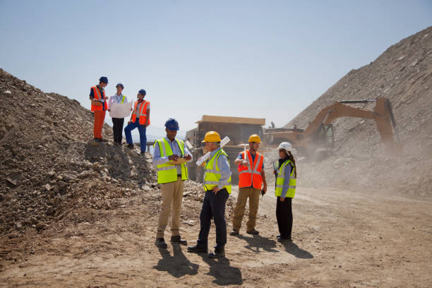 деловые люди и рабочие разговаривающие в карьер - construction worker earth mover truck quarry стоковые фото и изображения