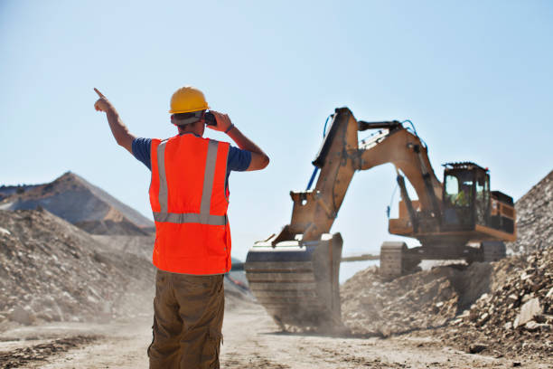 Worker directing digger in quarry  walkie talkie photos stock pictures, royalty-free photos & images