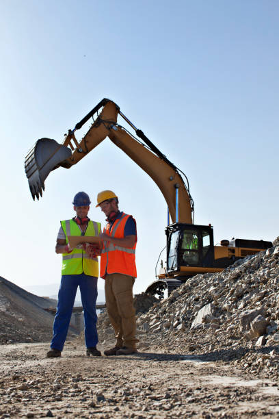 trabajadores hablando por digger en quarry - off road vehicle fotos fotografías e imágenes de stock