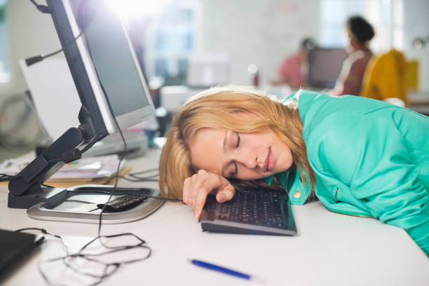 Businesswoman sleeping at desk stock photo