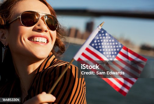 istock Woman waving American flag by urban bridge 164853304